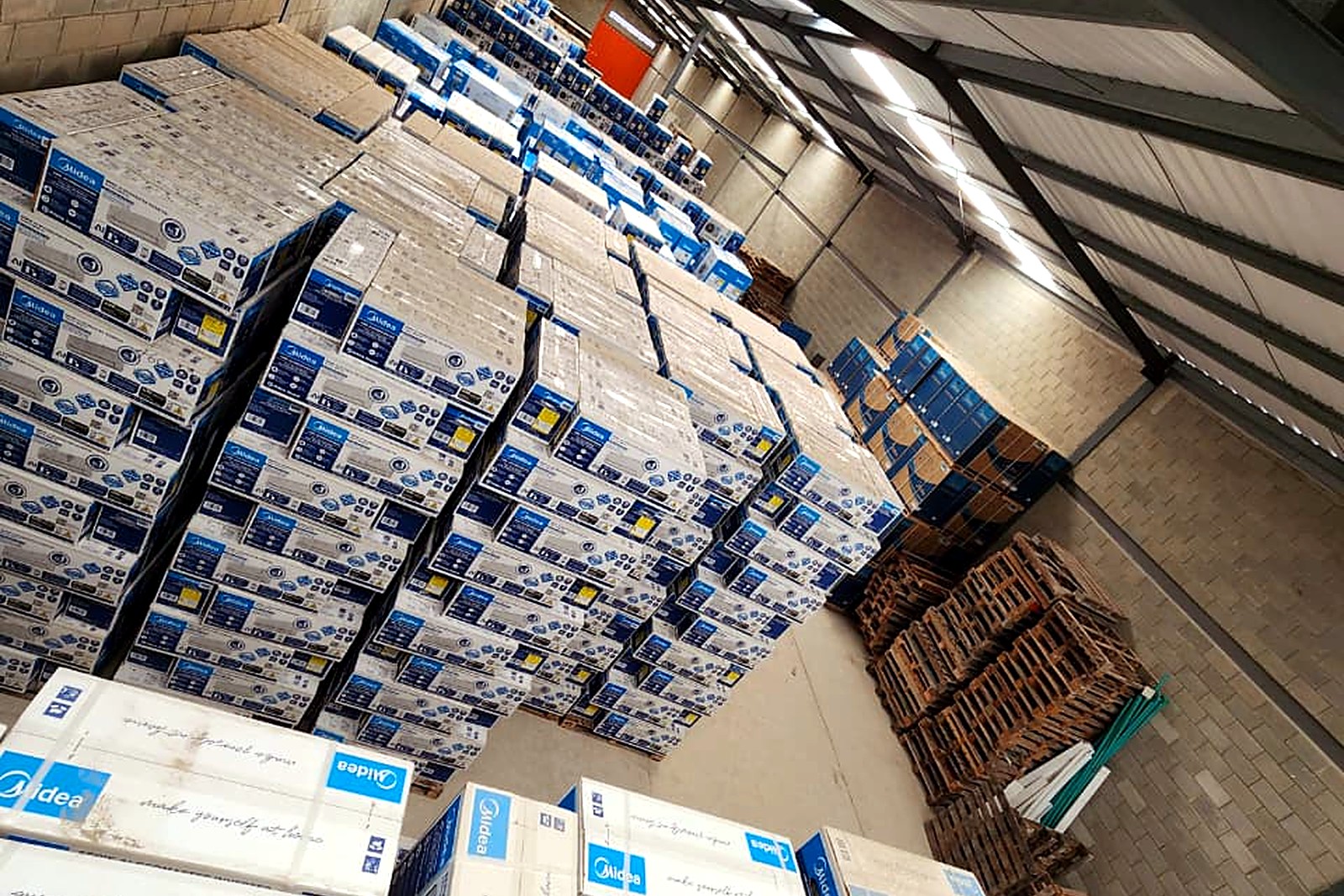Vista interna de la bodega de REMODEL BIS con pallets de equipos de aire acondicionado listos para despacho